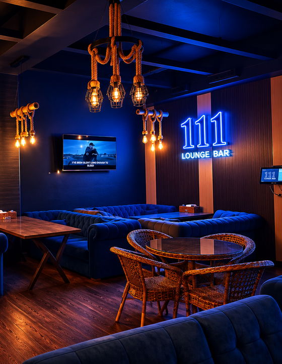 Kechqurun 111 Lounge Bar asosiy zali: muassasa nomi yozilgan koʻk neon, chesterfild divanlar va arqon chiroqlar